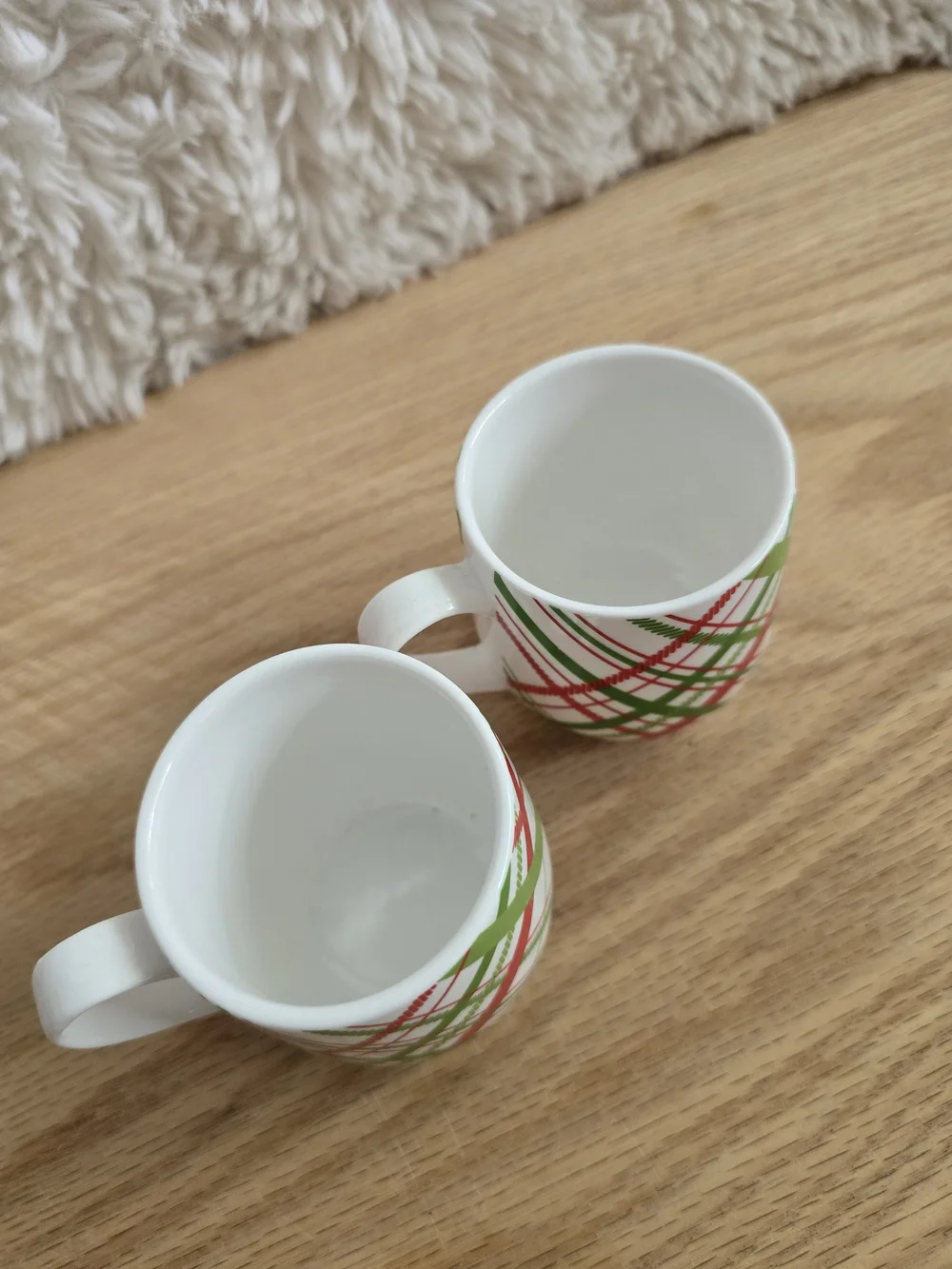 Crate & Barrel brand holiday mugs featuring a red and green plaid pattern